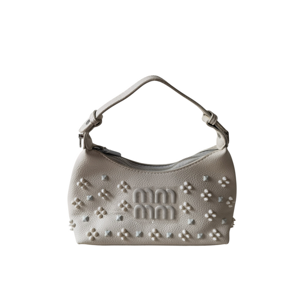 Cartera pequeña ZEFORA Bella en color crema con silueta curva, detalles en relieve y asa superior elegante.