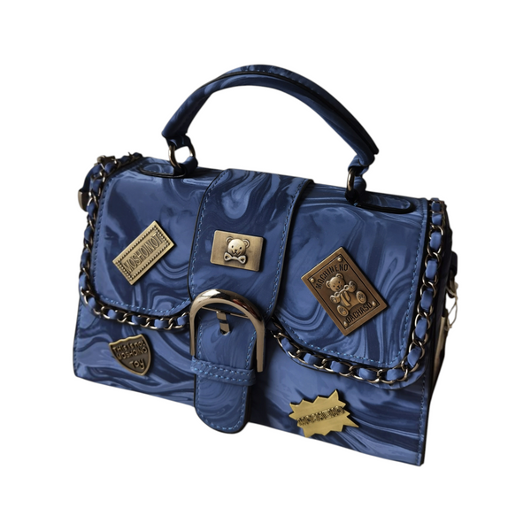 Cartera ZEFORA azul con diseño marmoleado, hebilla frontal, detalles metálicos decorativos y cadena estilo urbano.