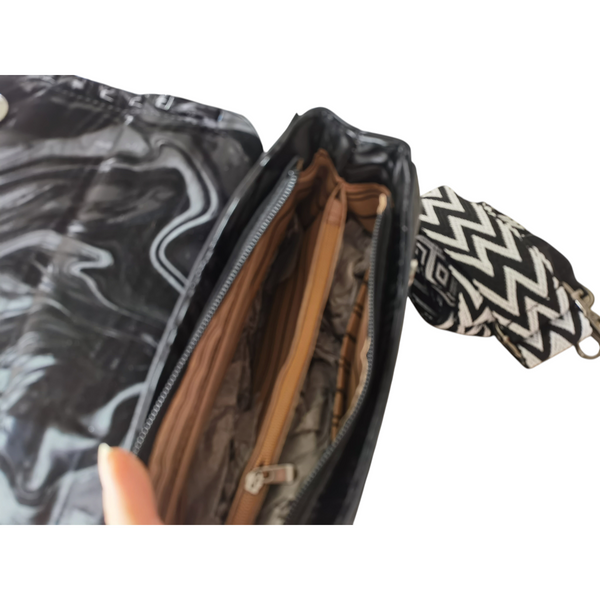 Interior de la cartera Dakota ZEFORA en color negro con forro beige, compartimentos con cierre y correa estampada