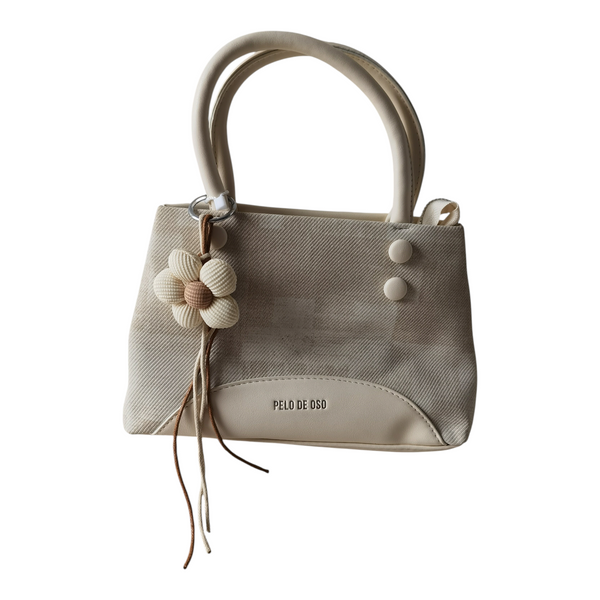 Cartera ZEFORA Isabella color crema con textura, asas redondeadas, bolsillo frontal y colgante de flor decorativo.