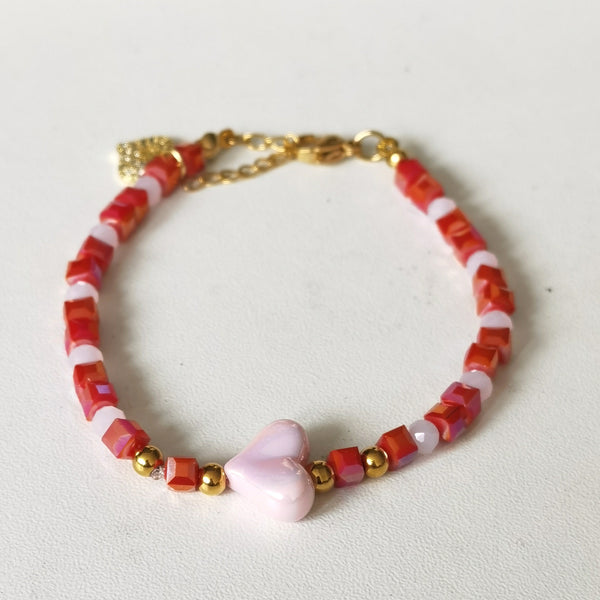Descubre la pulsera Sweet Heart de 16.5 cm, con cuentas rojas y blancas, detalles dorados y corazón rosado. Un accesorio romántico y femenino.