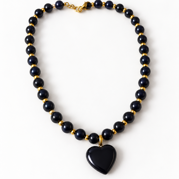 Descubre nuestro collar de cuentas negras con dije de corazón y detalles dorados. Un accesorio moderno, elegante y versátil. Compra en Zefora Accesorios.