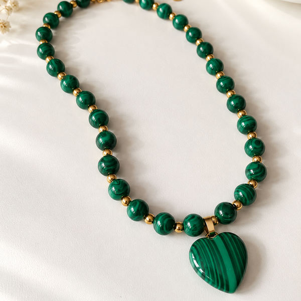 Collar de cuentas verdes estilo malaquita con dije de corazón y detalles dorados. Una joya elegante y femenina para complementar tus looks.